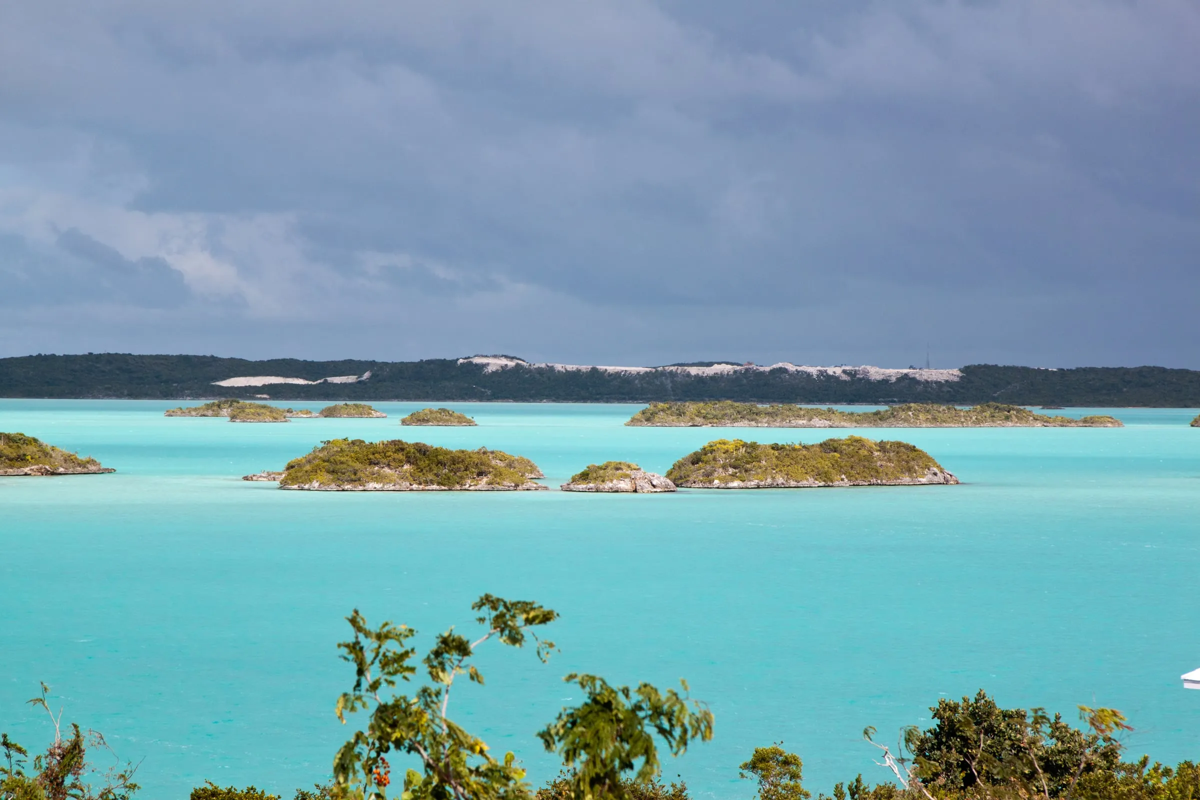 Chalk Sound’s turquoise lagoon scattered with small green cays, seen over coastal scrub